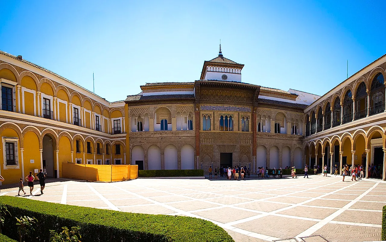 De Patio de la Montería en de gevel van het paleis van Pedro I onder een heldere blauwe hemel