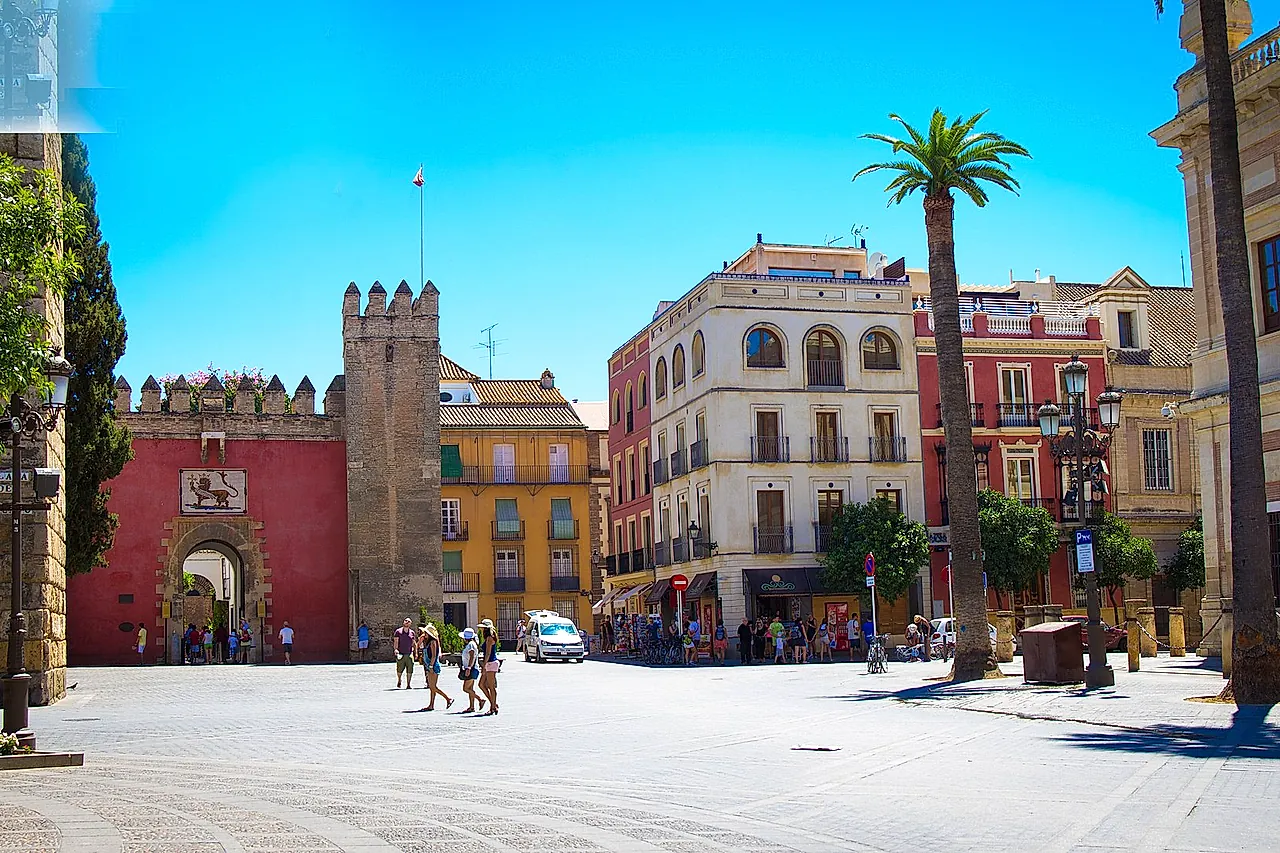 La Puerta del León con la torre merlata su Plaza del Triunfo, sotto un cielo azzurro