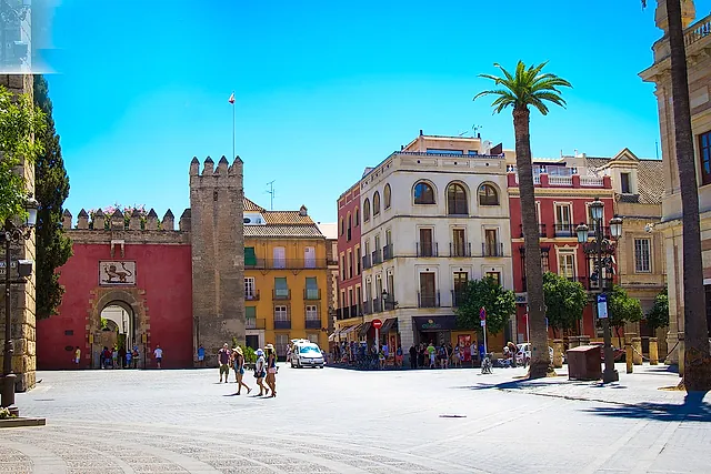 Die Puerta del León und ihr Zinnenturm an der Plaza del Triunfo unter blauem Himmel